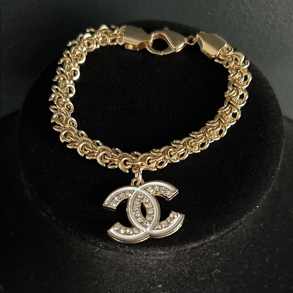 CHANEL Jewelry - CHANEL White & Crystal Logo Charm on Gold Filled 7 inch Bracelet.